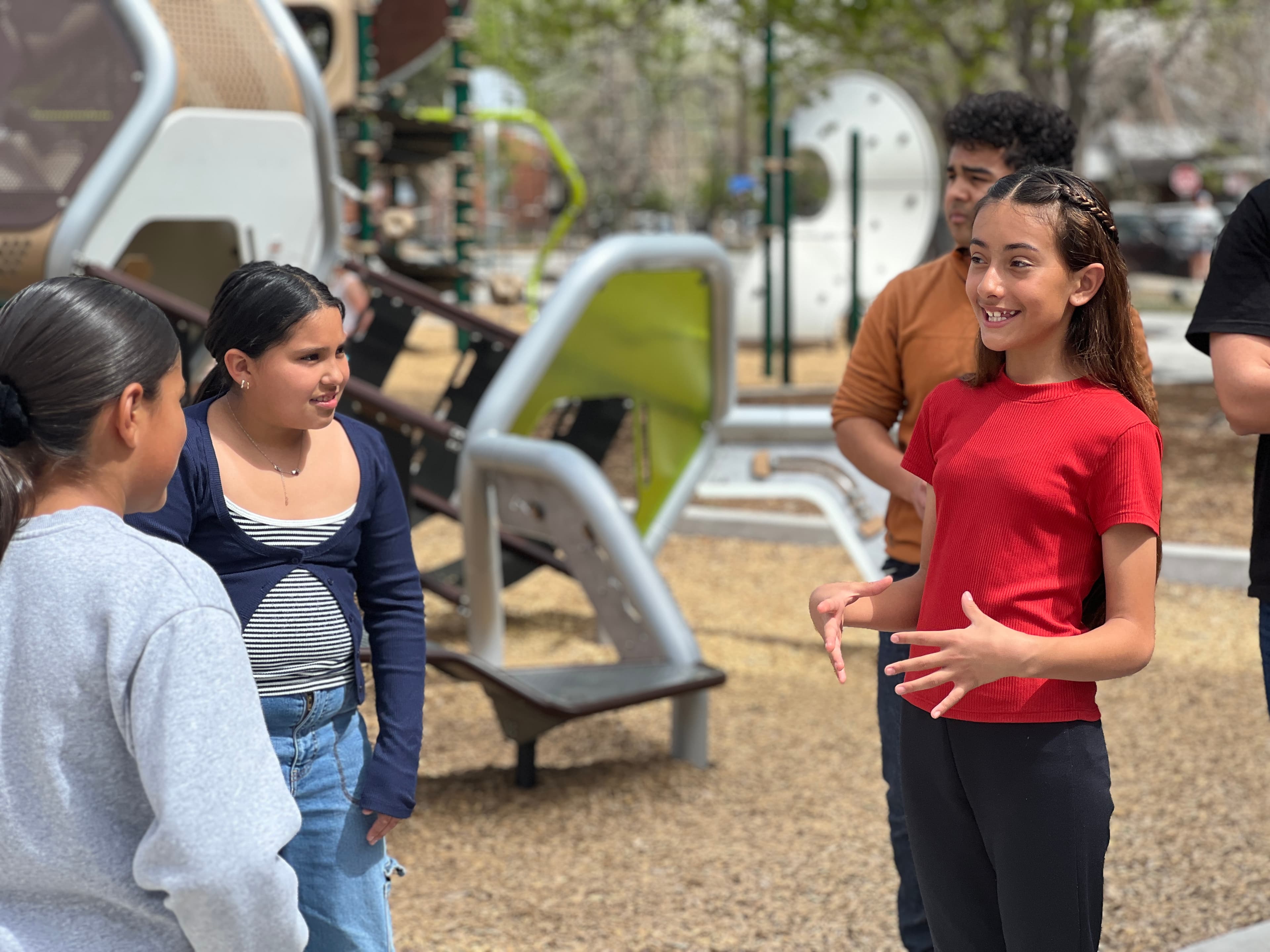 Joven hablando con confianza y una sonrisa ante su grupo